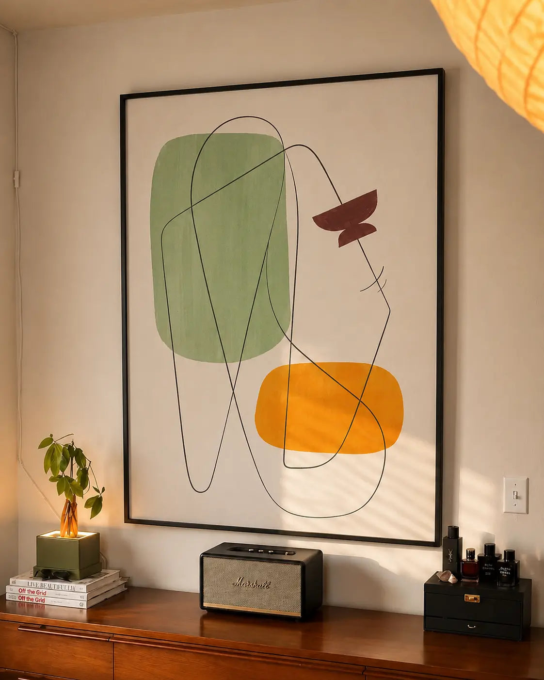 Black-framed geometric wall art with green, yellow, and dark line abstract shapes
