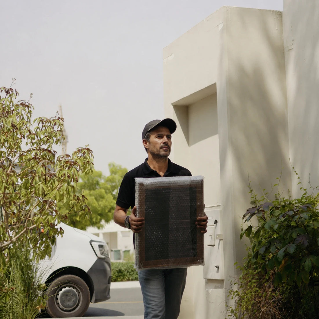 Wrapped Joffzart framed artwork being carried for delivery