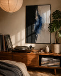 Abstract wall art print in black frame with blue watercolor strokes on a light background