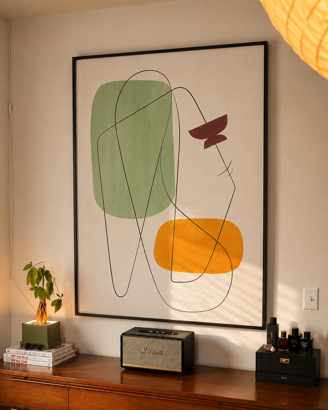 Black-framed geometric wall art with green, yellow, and dark line abstract shapes