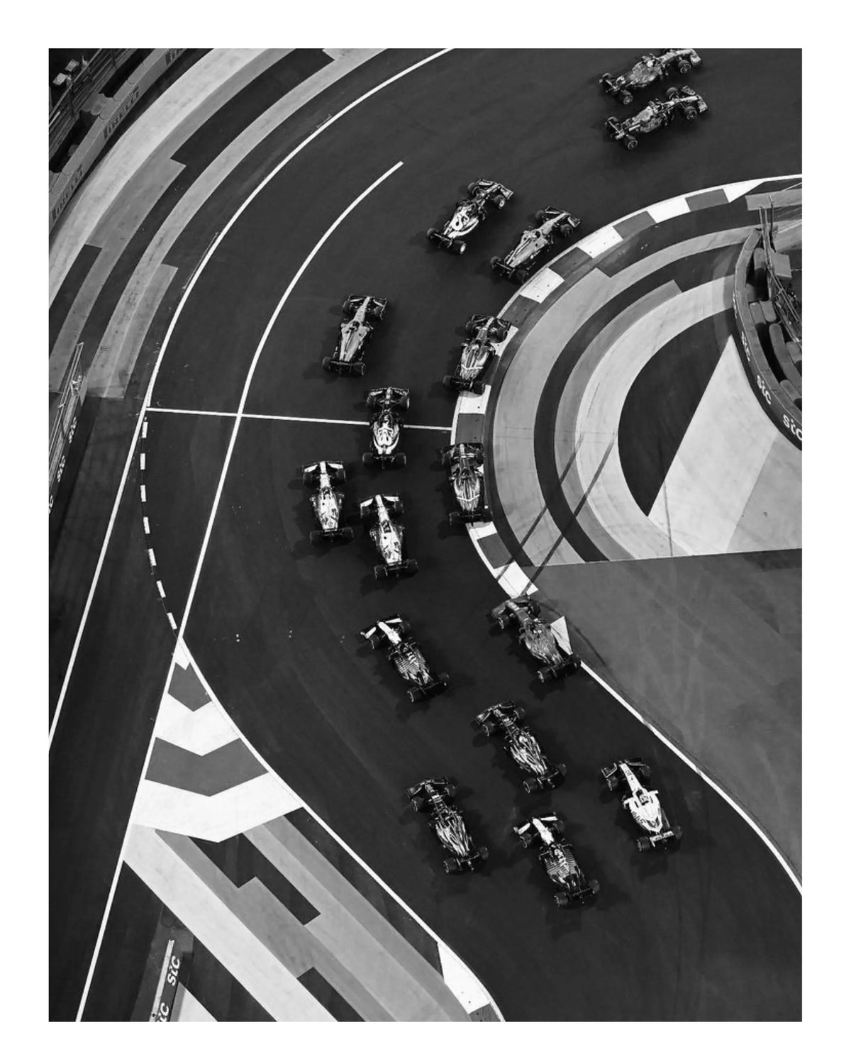 Black-and-white racing track art print close-up with cars on a curved circuit