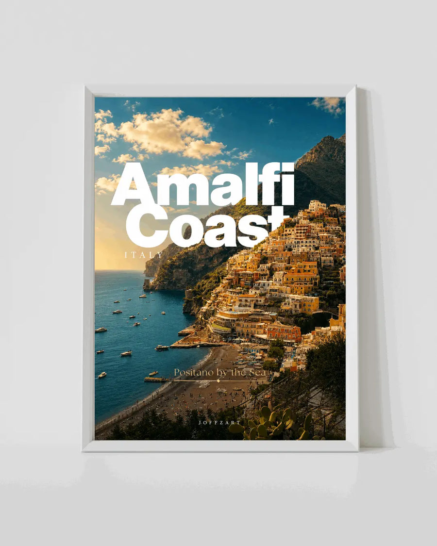 White-framed coast travel poster with sea cove and cliffside town buildings