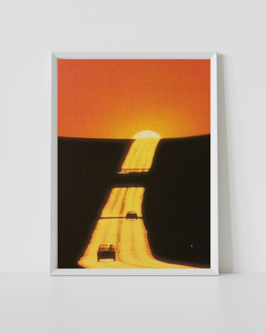 Póster Golden Exit, marco blanco; atardecer naranja sobre carretera oscura