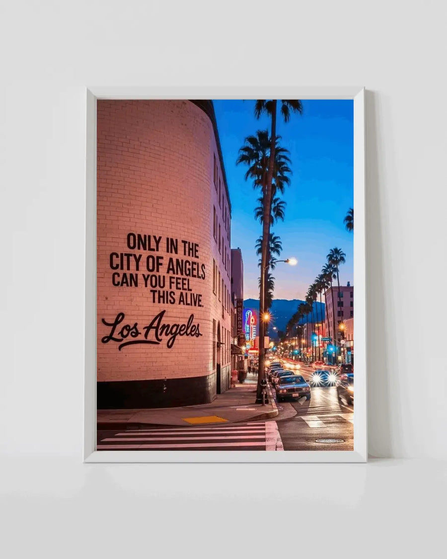 White-framed city street wall art print with brick wall quote, palm trees, and lights