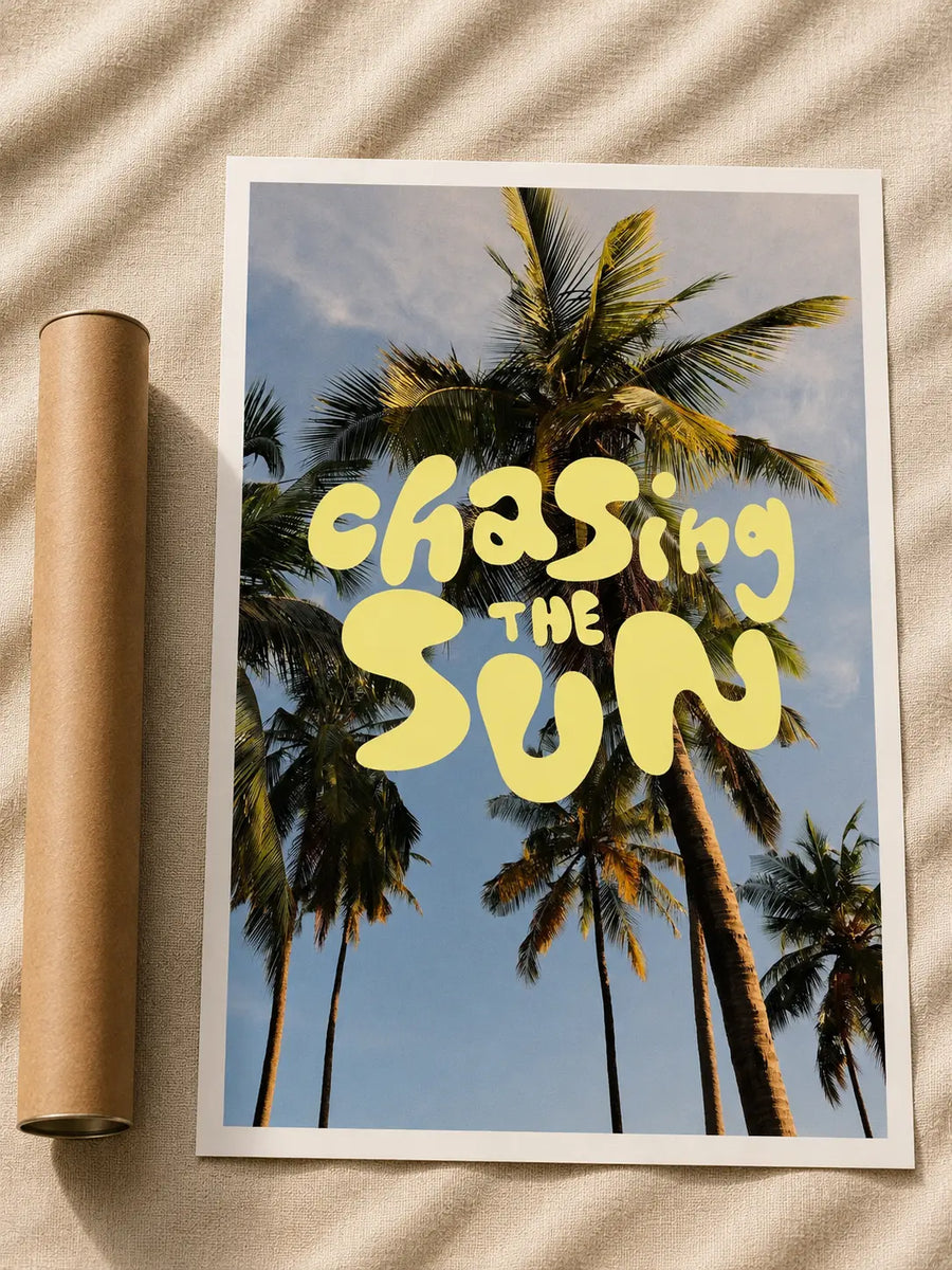 White-framed typography print: yellow 'Chasing the Sun' over palm trees