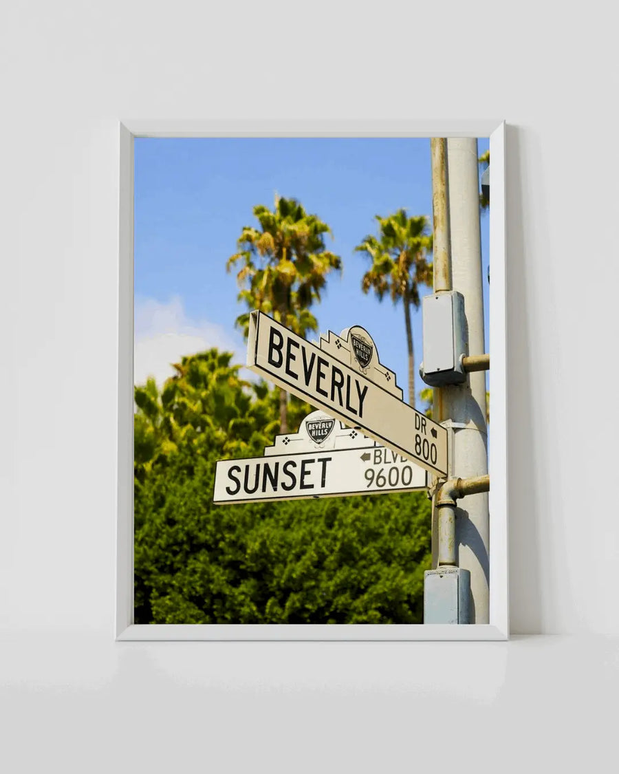 White-framed street sign wall print with palm trees and blue sky