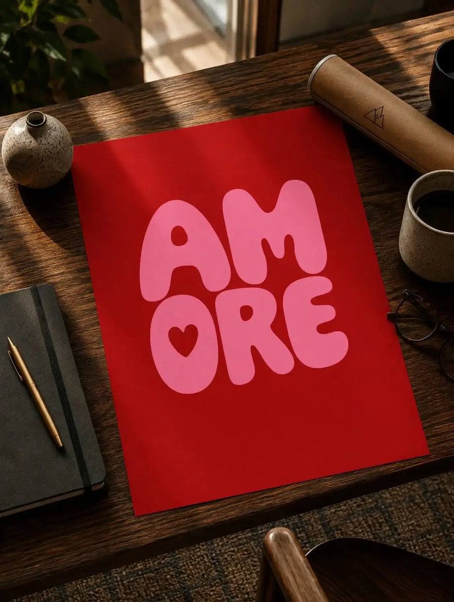 Red typographic print with pink letters and heart, shown on a wooden desk