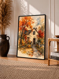 Black-framed watercolor cottage art print with autumn trees and garden path