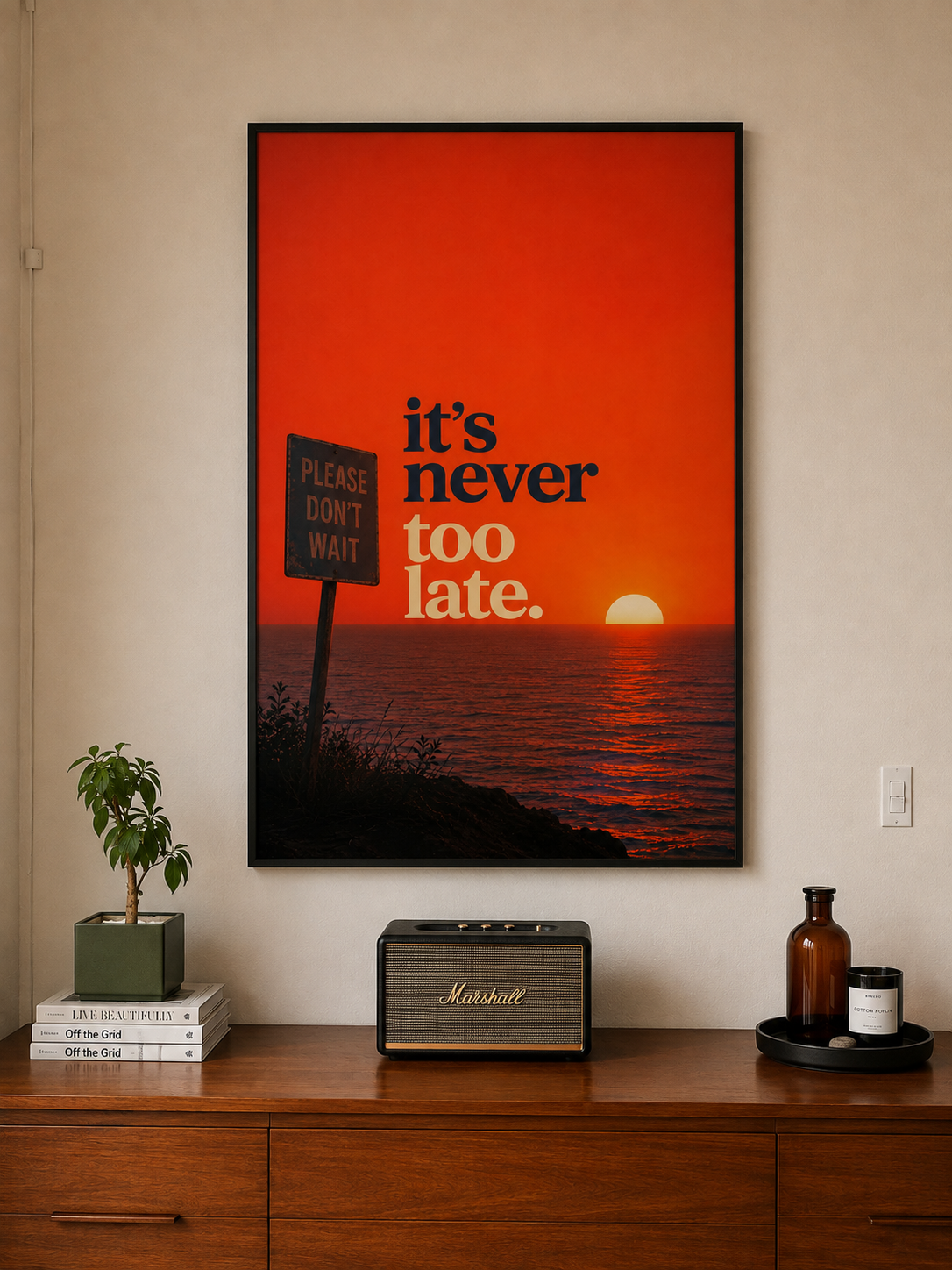 Black-framed motivational wall art with “it’s never too late” on an orange sunset background.