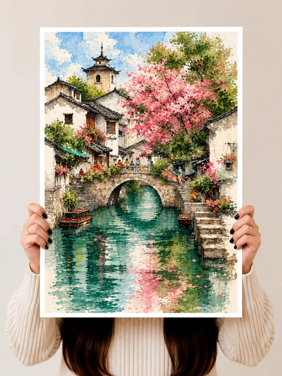 Cottage Garden Watercolor Art Print held vertically to show the stone cottage, arched bridge and colorful garden