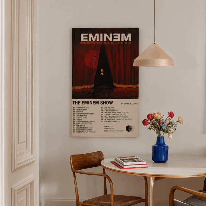 Framed rap music wall print with black border on wall above side table and flowers