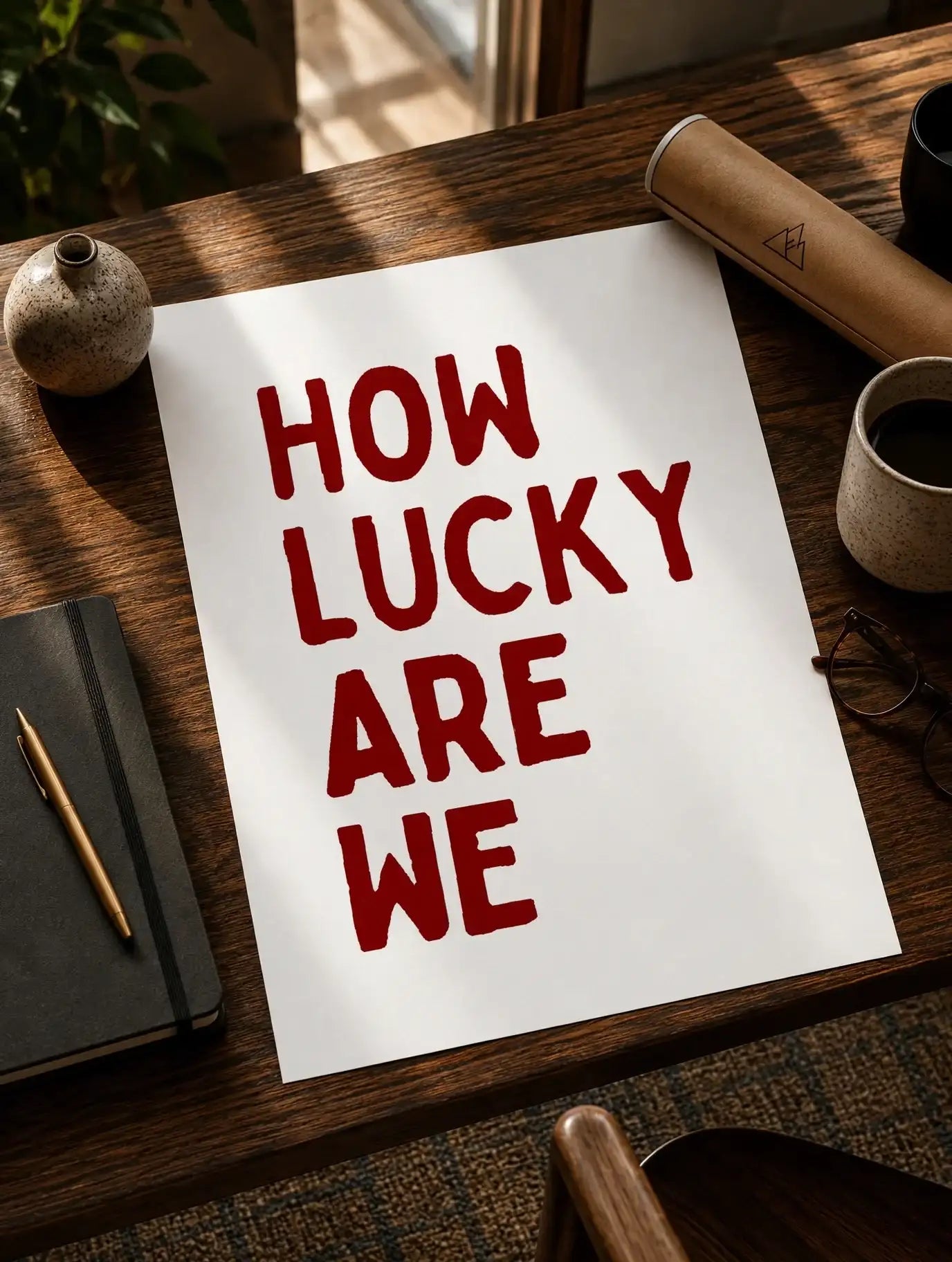 Quote print paper with red 'How lucky are we' text on wooden desk