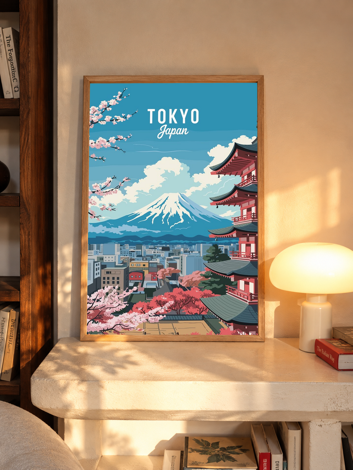 Japanese Cherry Blossoms Wall Art displayed in a warmly lit room beside a glowing table lamp, with a framed Tokyo design combining pink blooms, a red pagoda and snow-capped Mount Fuji.