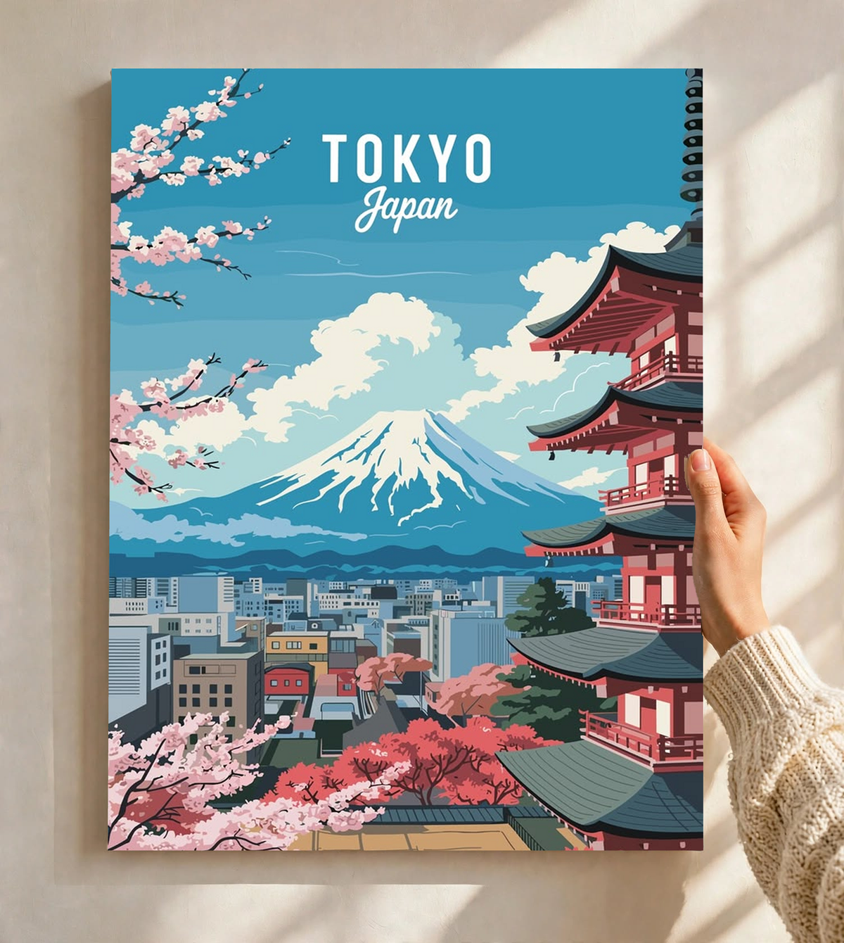 Japanese Cherry Blossoms Wall Art shown close up in a light frame, with Tokyo lettering above a turquoise sky, snow-capped Mount Fuji, a red pagoda and pink blooms across the foreground.