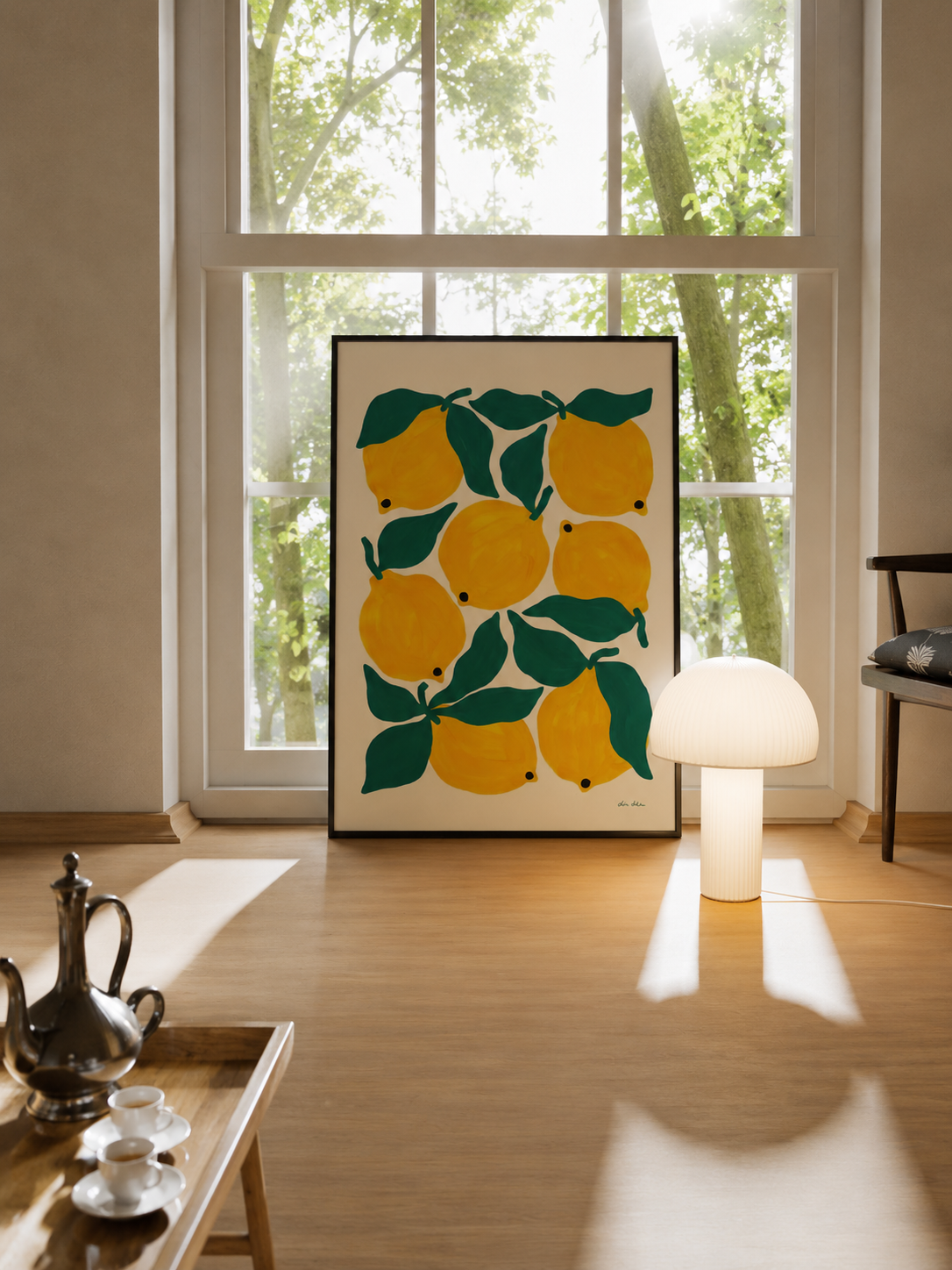 Framed lemon and green leaf art print with yellow fruit on a wall, dark frame