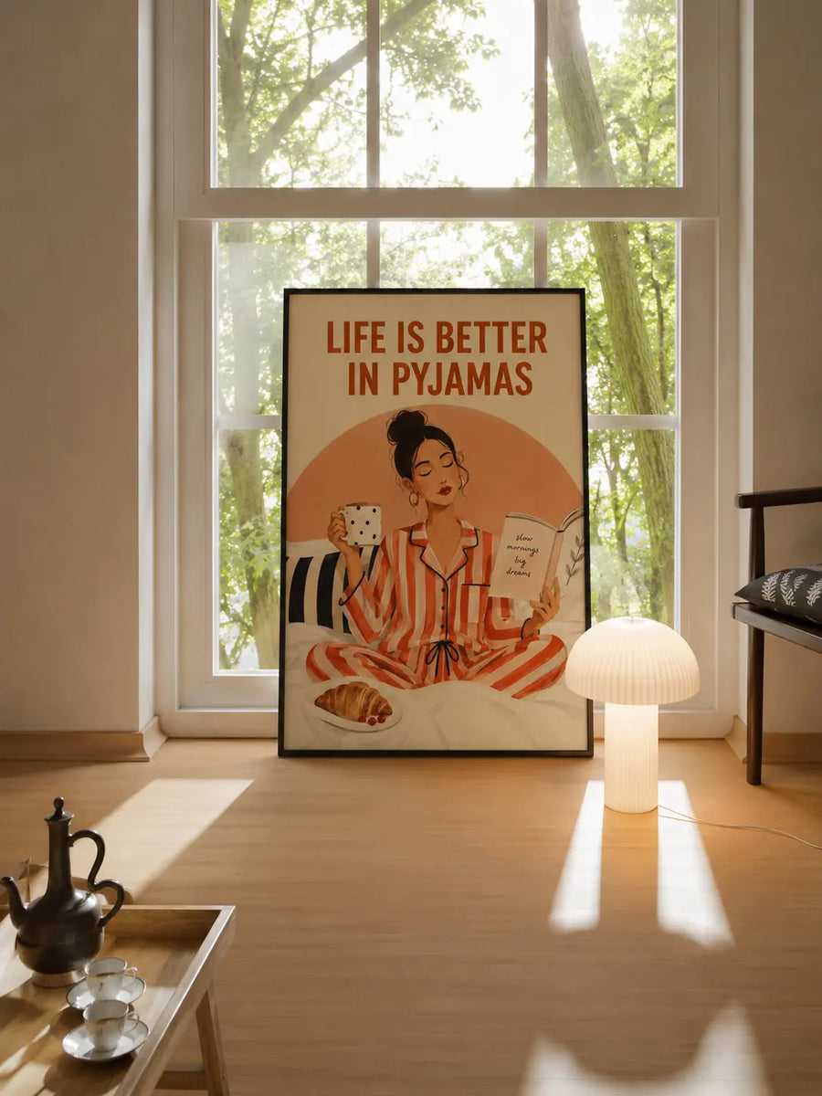Framed wall art standing by window, woman in pajamas holding mug and open book