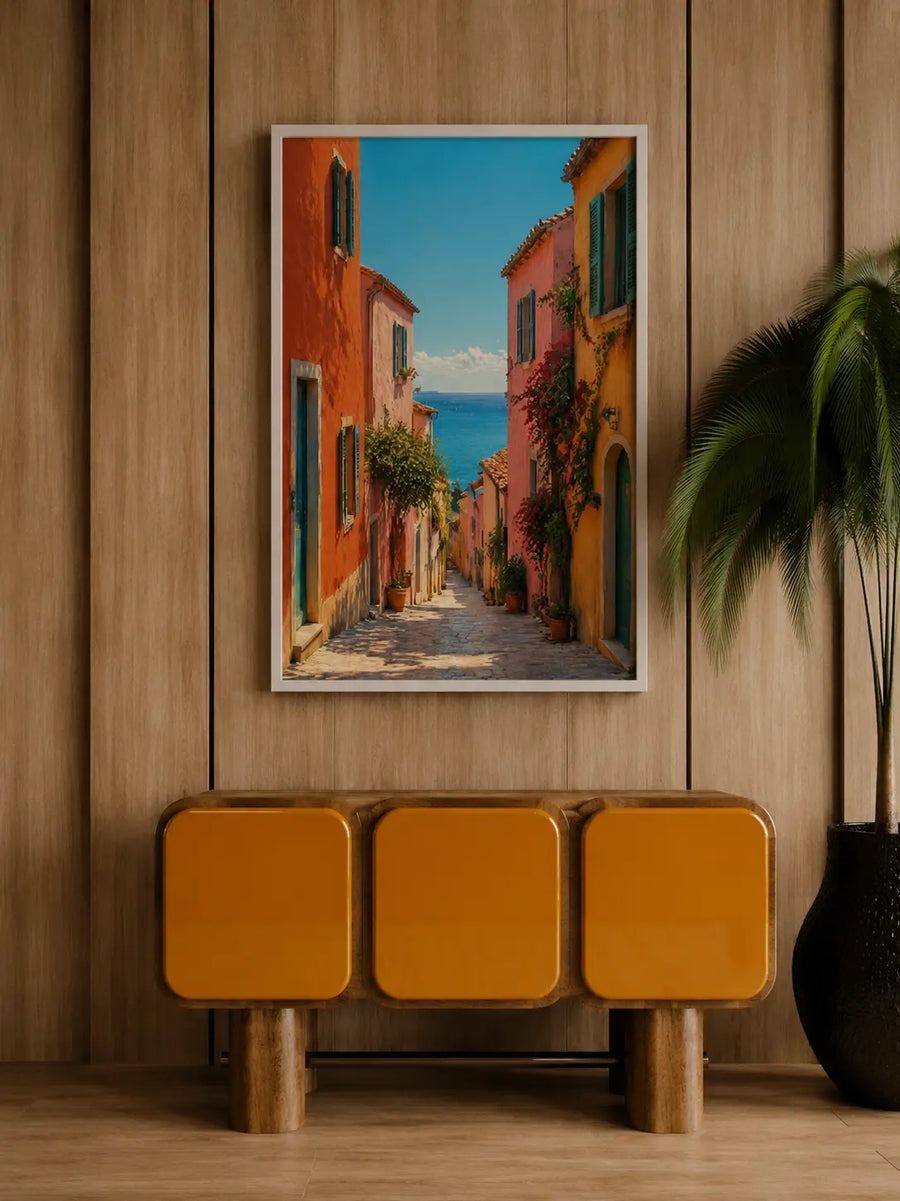Impresión enmarcada en madera de un estrecho callejón costero con edificios coloridos y el horizonte del mar