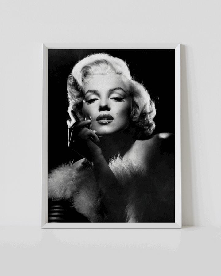 White-framed black-and-white Marilyn Monroe portrait poster with hand on her cheek