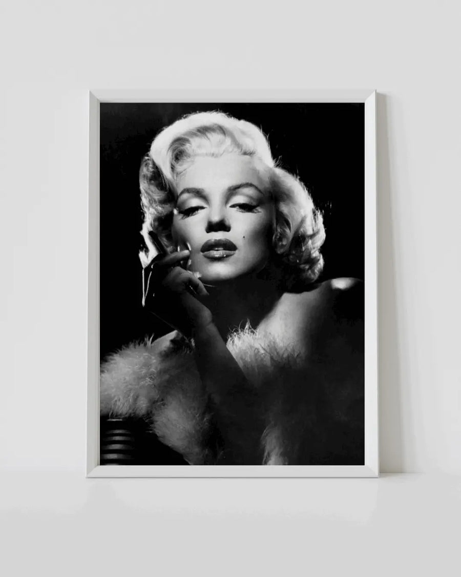 White-framed black-and-white Marilyn Monroe portrait poster with hand on her cheek