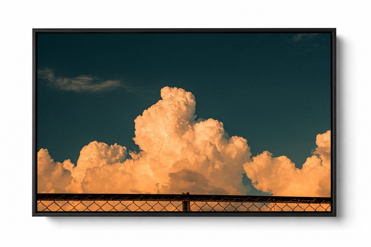 Black framed Orange Cloud Sky Wall Art presented against a clean white background, showing illuminated orange cloud clusters, subtle shadowed edges and a wide stretch of dark teal sky.