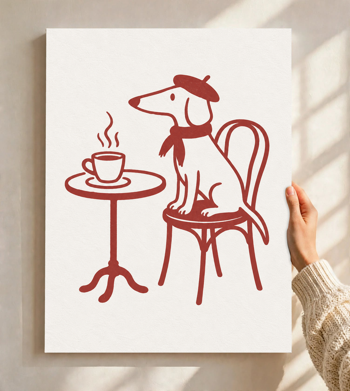Cane dal muso lungo con basco e sciarpa su una sedia da bistrot, vicino a una tazza fumante e un tavolino rotondo, a linee rosse su crema, come poster senza cornice tenuto contro una parete chiara con morbide ombre della finestra.