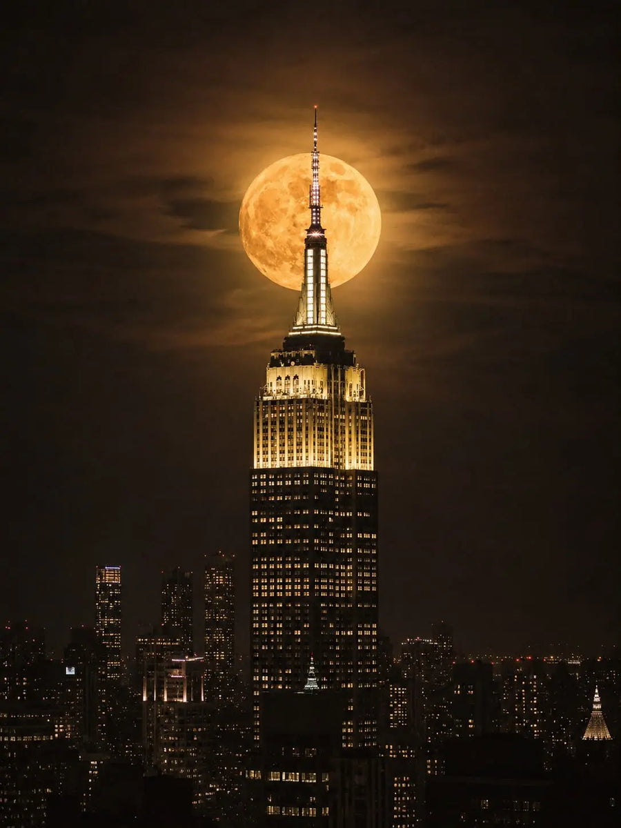 Unframed poster of Empire State Building with full moon overhead