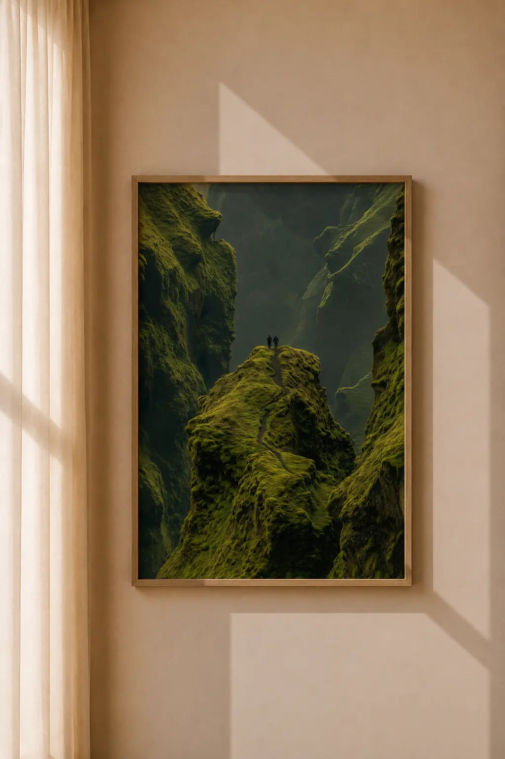 Brown-framed green valley wall art print with mossy cliffs and hikers on a ridge