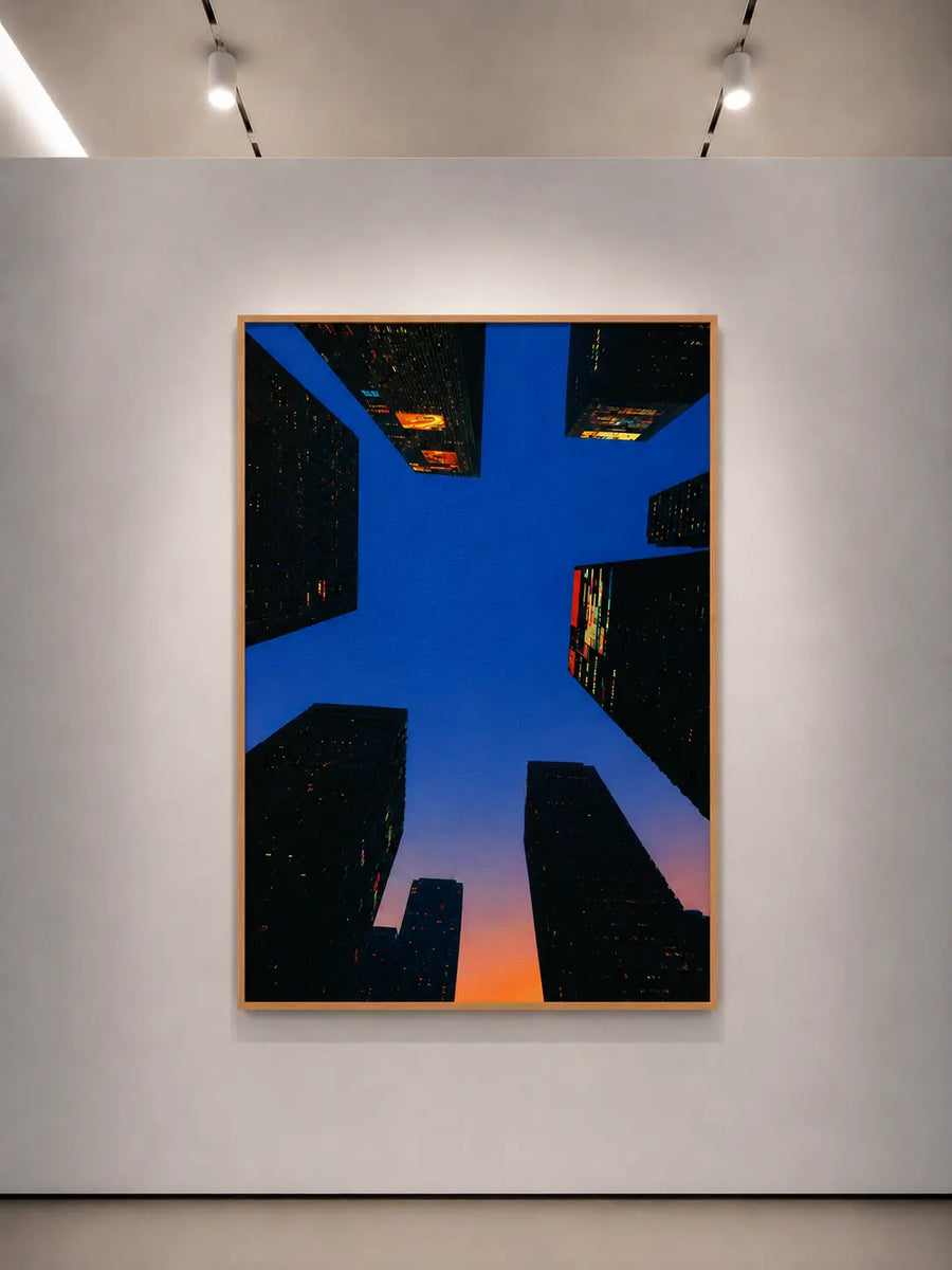 Impresión artística mural con marco naranja, bloques de ciudad azules y un degradado naranja de atardecer