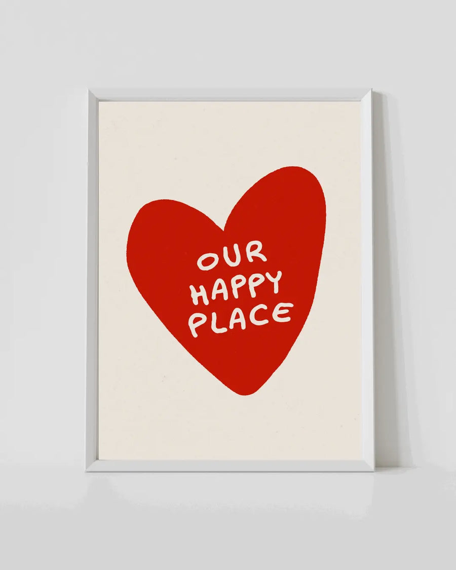 White-framed wall print with red heart and 'Our Happy Place' text