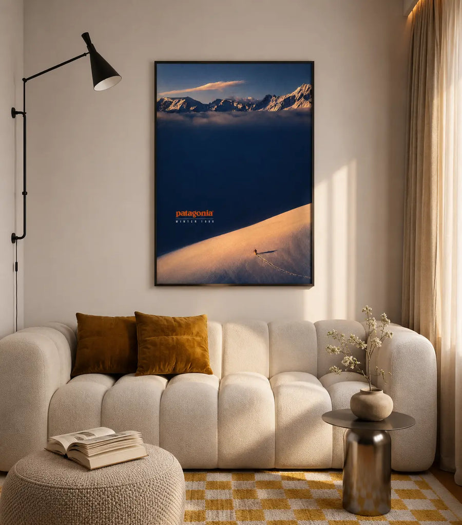 Framed landscape sunset print with mountain peaks and Patagonia logo on living room wall.
