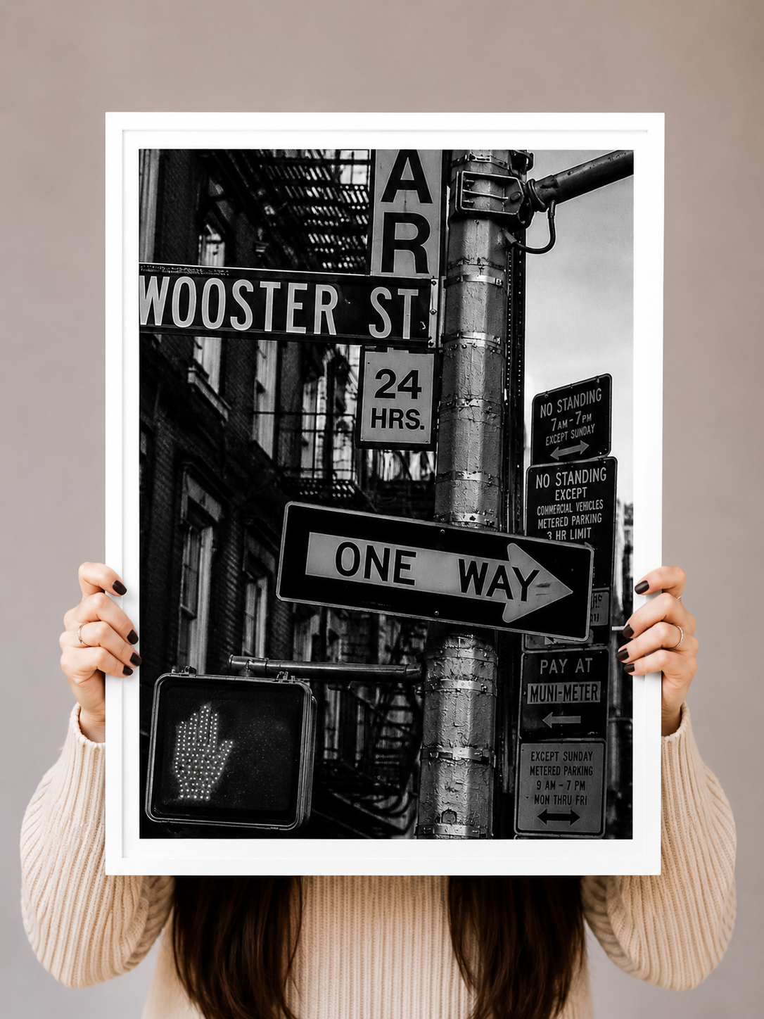 New York Street Sign Art Print with dense urban lettering set against a in a white frame dramatic monochrome city backdrop