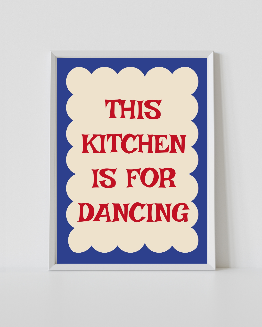 Framed kitchen quote print, white frame, blue background with red “THIS KITCHEN IS FOR DANCING”.