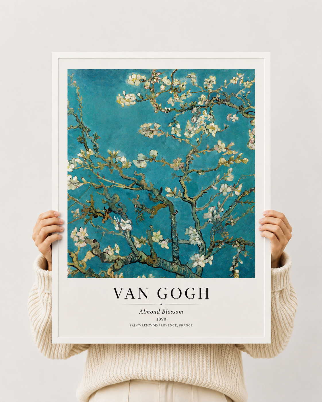 Almond blossom art print in white frame held by hands; teal sky and white blossoms on branches