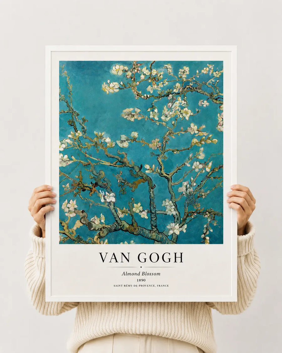 Almond blossom art print in white frame held by hands; teal sky and white blossoms on branches