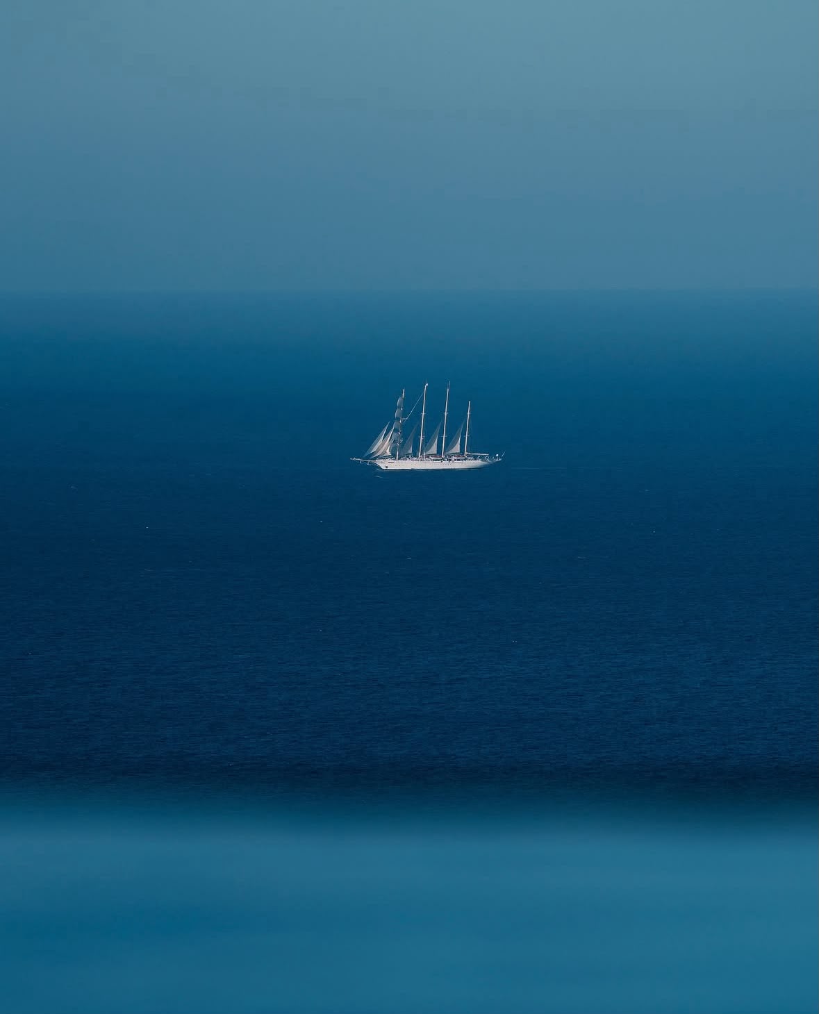 Close-up blue sailboat wall art print with small sailboat in center