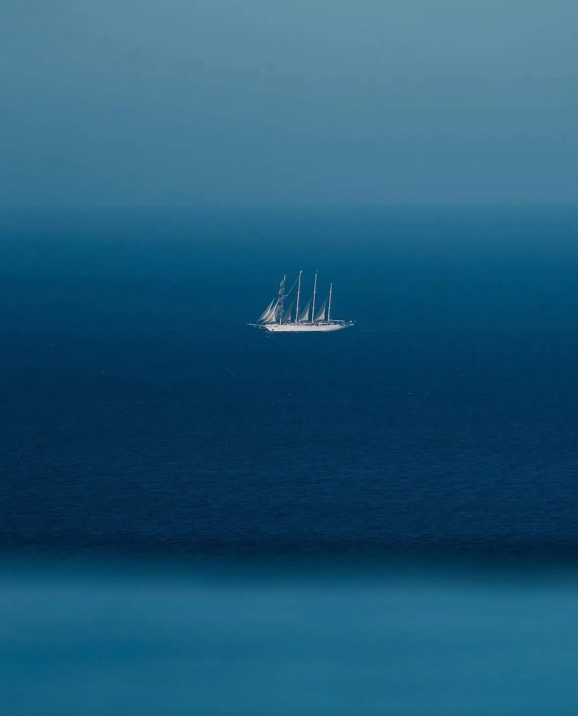 Close-up blue sailboat wall art print with small sailboat in center