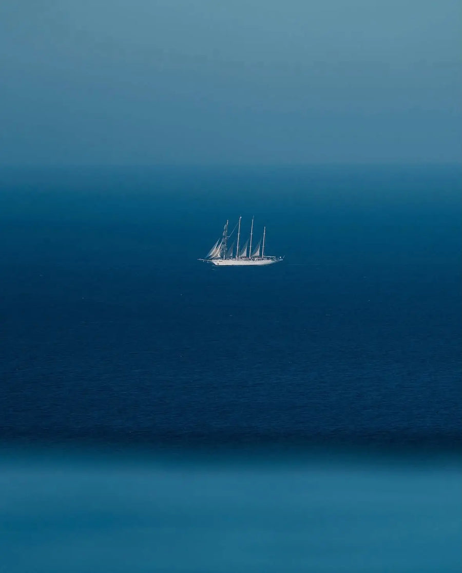 Close-up blue sailboat wall art print with small sailboat in center