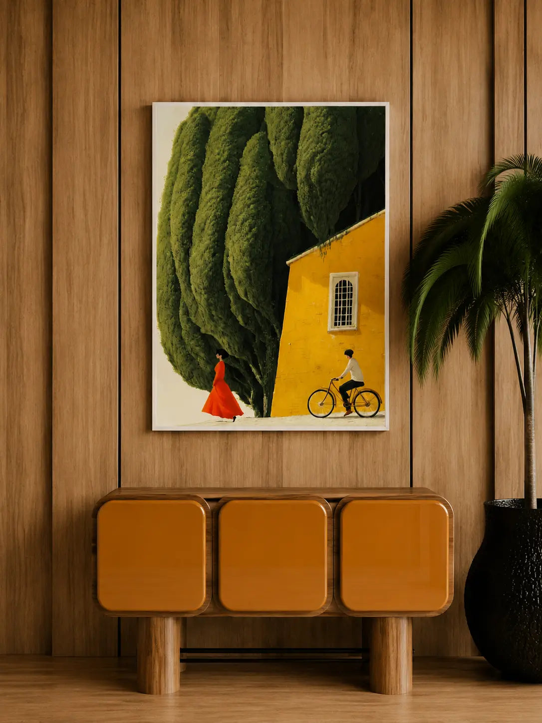 Framed wall art print showing green canopy, yellow building wall, orange dress figure, and bike rider