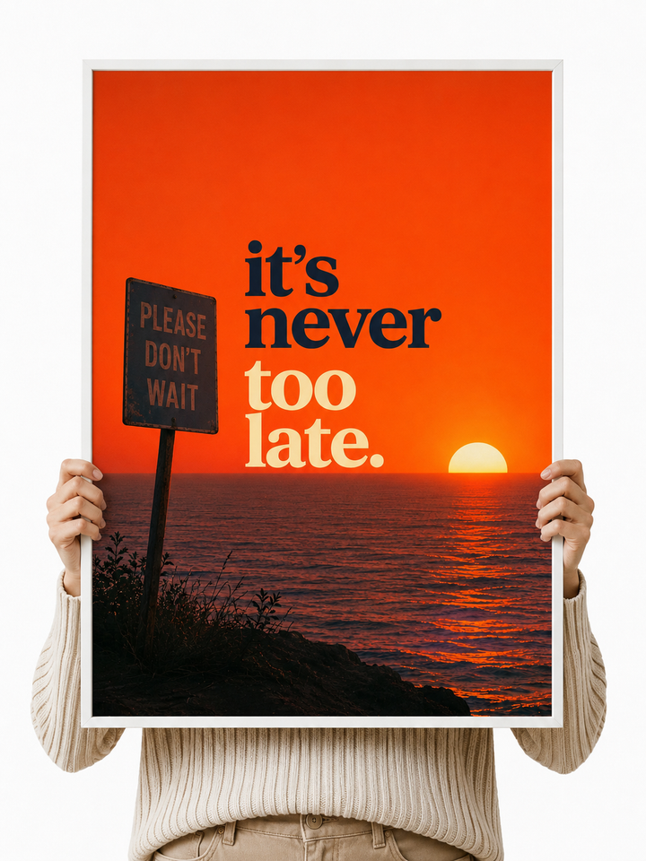 Unframed motivational poster with “it’s never too late” over orange sunset and sign.