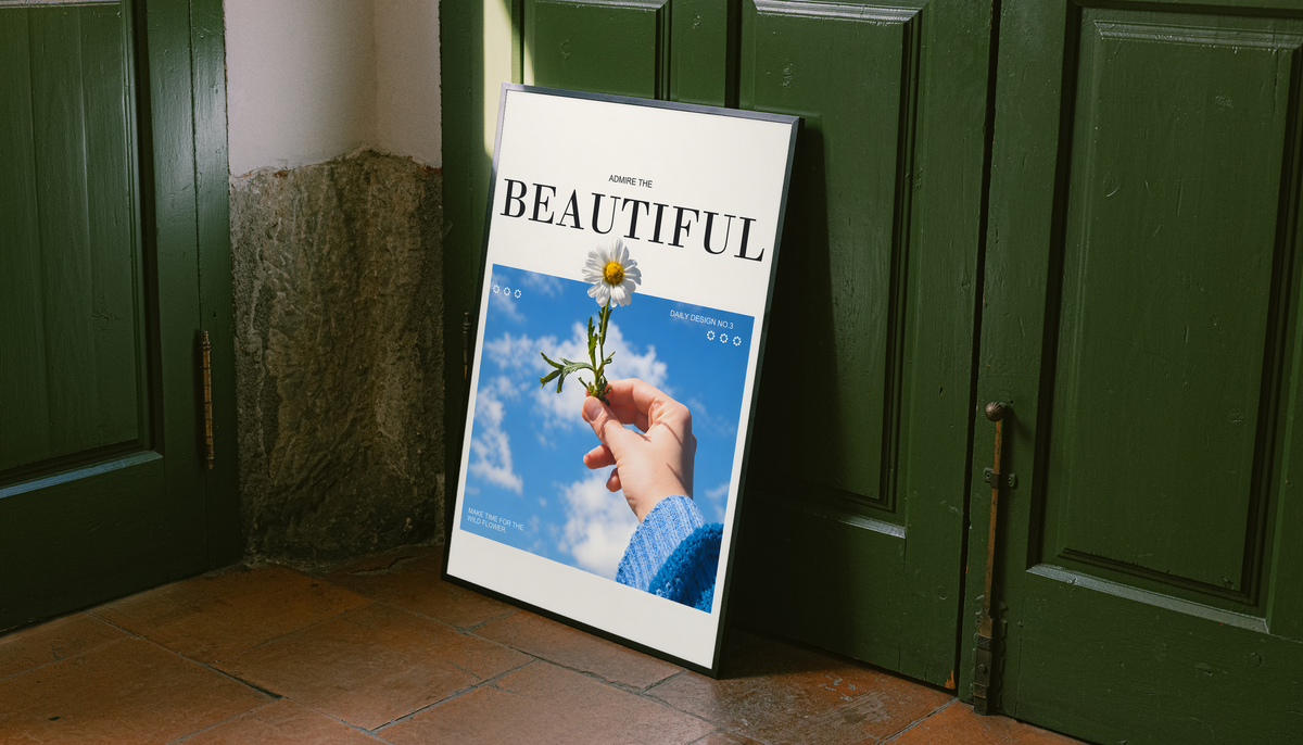 Hand holding a white daisy under blue sky with Admire the Beautiful lettering; unframed canvas styled by a green doorway