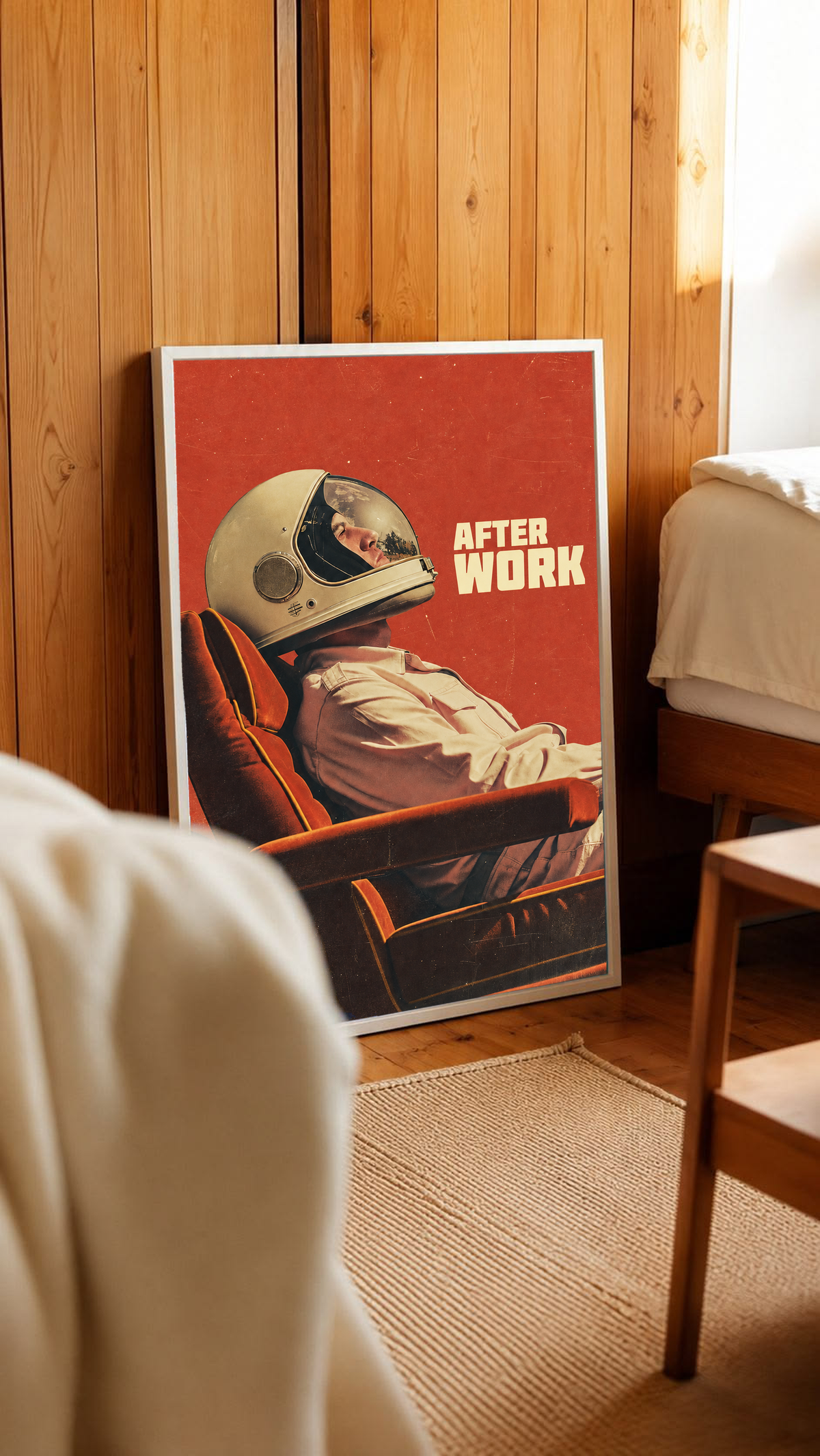 An astronaut reclining in an armchair against a burnt-orange ground in a white frame leaning against warm wooden wall panels