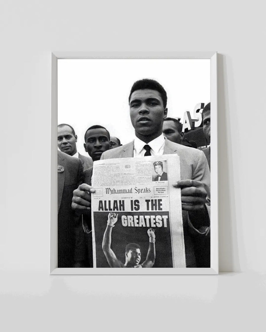 White-framed black-and-white poster of Muhammad Ali holding newspaper with 'ALLAH IS THE GREATEST'