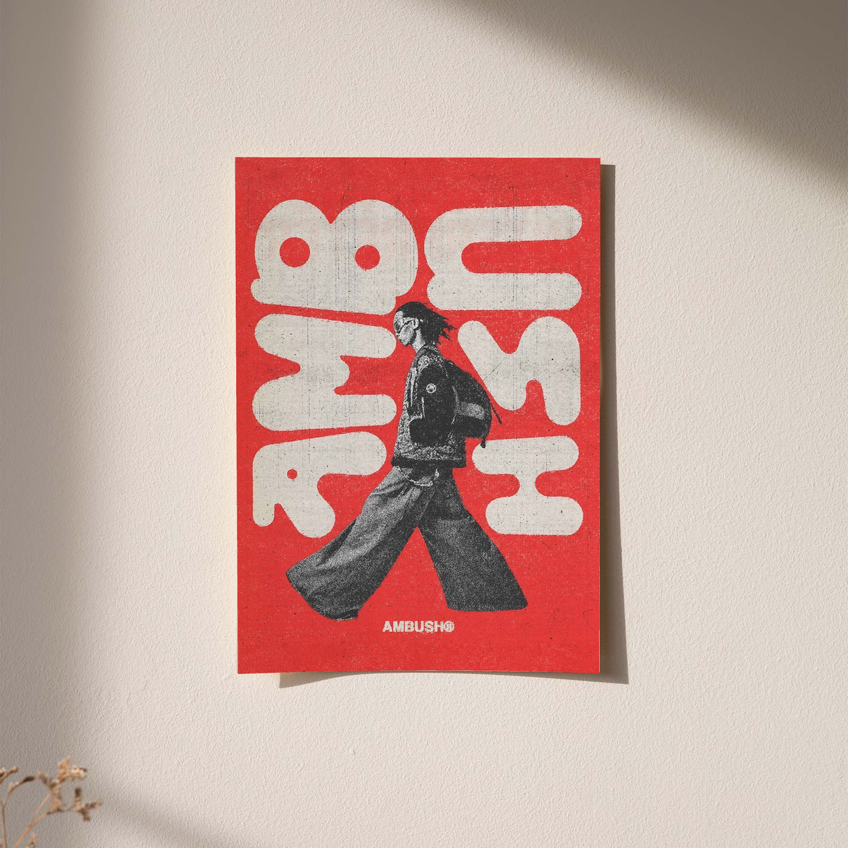 Red poster with white abstract typography and a black walking figure; AMBUSH text