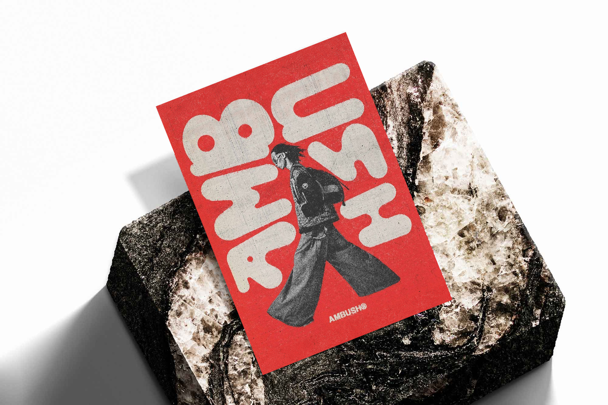 Red typography poster with white abstract letters and black walking figure on stone