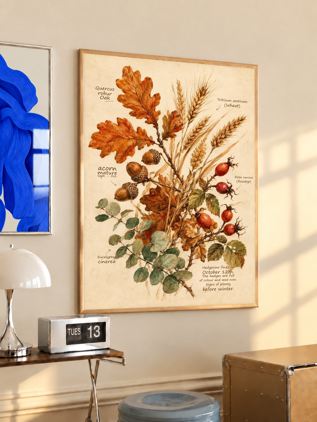 Framed botanical art print with oak leaves, wheat stalks, and rose hips in warm colors.