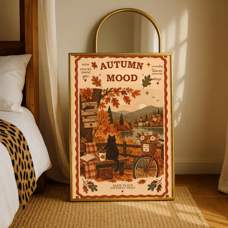 Framed autumn mood poster on floor by bed, black cat and bicycle in fall landscape