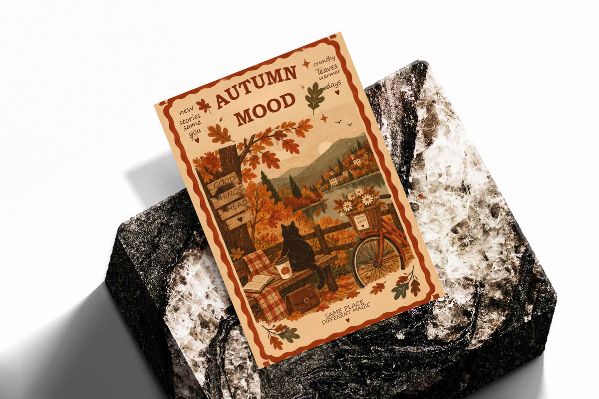 Framed autumn mood poster laid on textured stone, black cat, bicycle, fall foliage