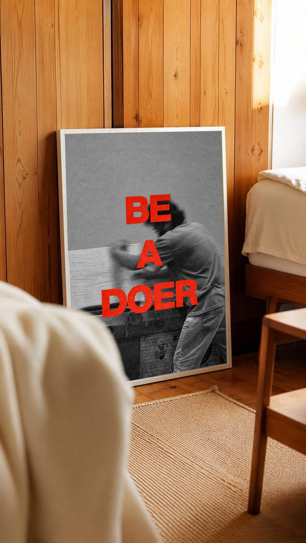 Red Be a Doer lettering over a motion-blurred monochrome figure in a white frame leaning against warm wooden wall panels