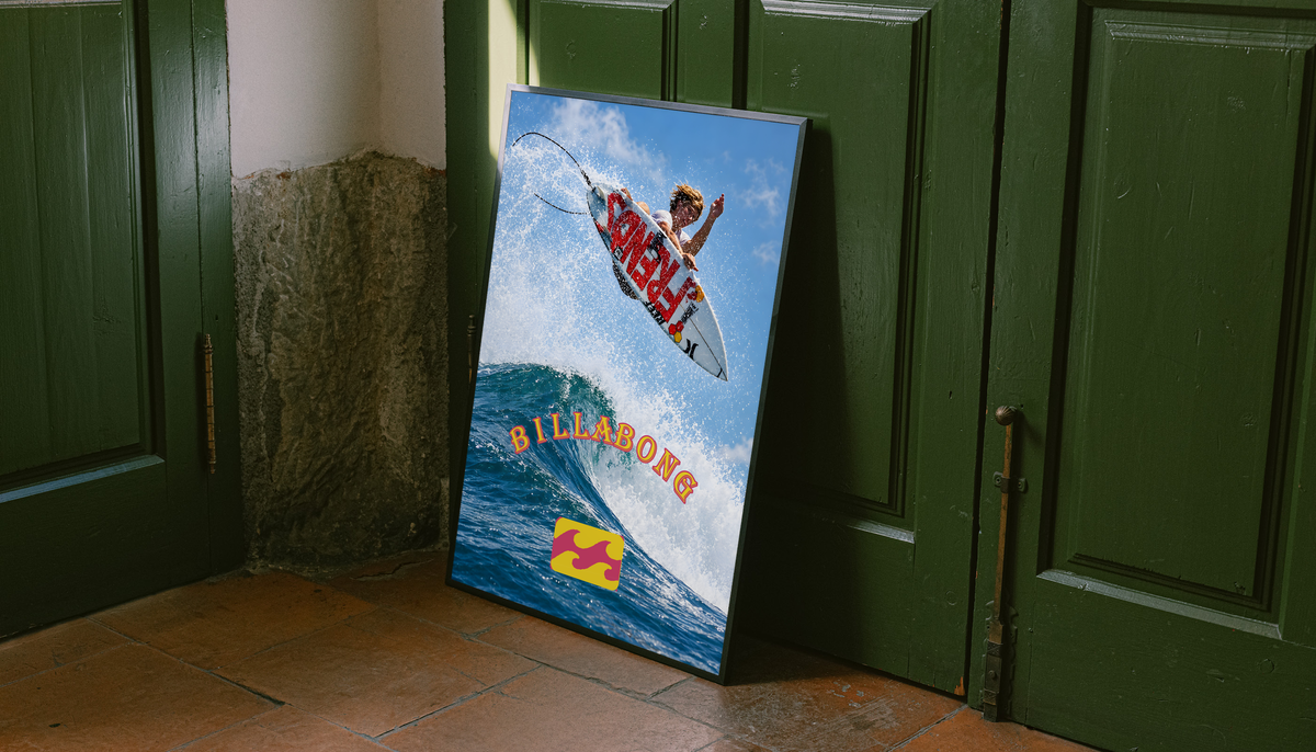 Airborne surfer above a blue wave with orange Billabong lettering; unframed canvas styled by a green doorway