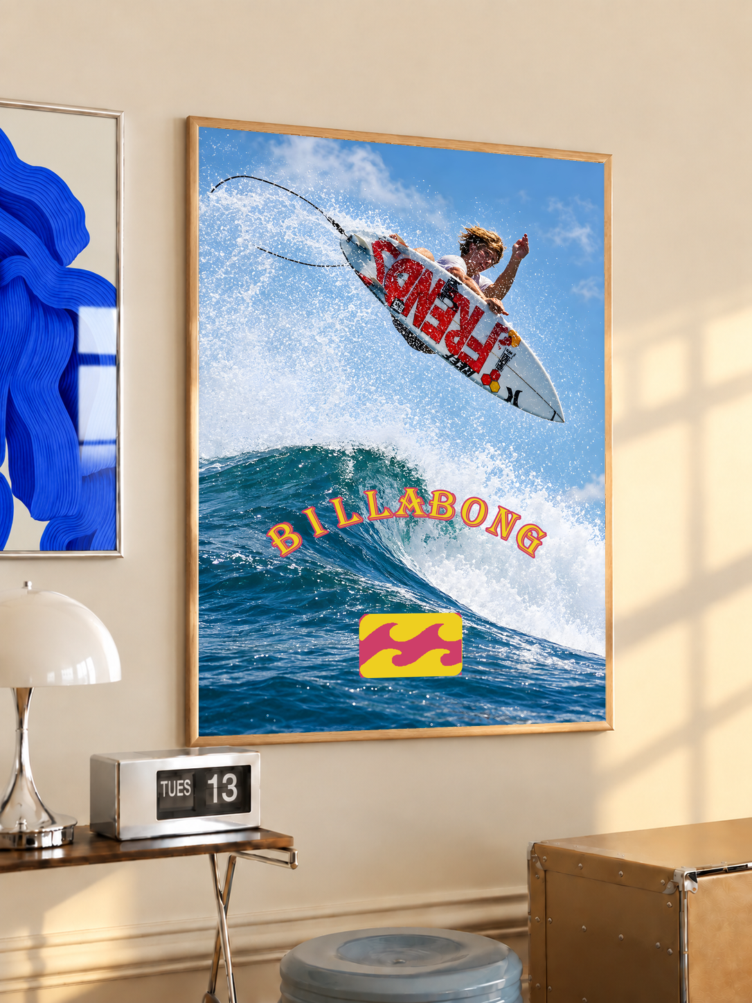 Airborne surfer above a blue wave with orange Billabong lettering; oak framed print in a desk setting